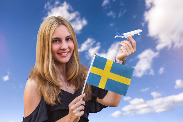 mädchen hält flagge von schweden und spielzeugflugzeug auf dem himmelshintergrund - passport sweden customs europe stock-fotos und bilder