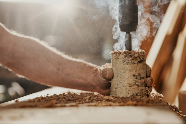 istock Carpenter using a high speed drill to drill a section of wood 1342388559