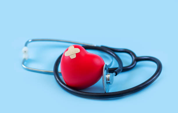 Red heart and stethoscope on blue medicine background Red heart and stethoscope on light blue background with copy space stroke illness photos stock pictures, royalty-free photos & images