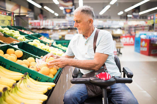 Hombre mayor con discapacidad en las compras photo
