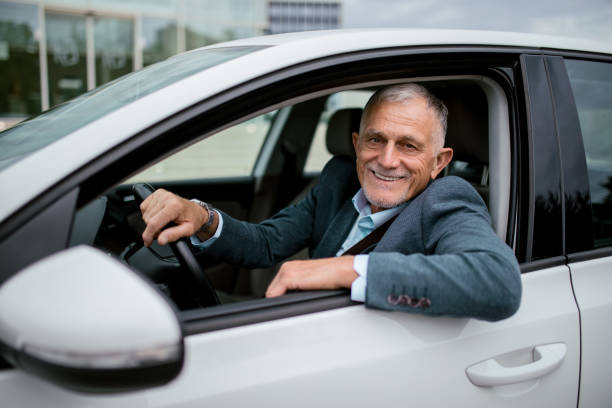 istock Man wearing business suit driving a car 1342393608