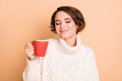 Photo portrait of female student enjoying hot coffee aroma dreaming isolated on pastel beige color background.