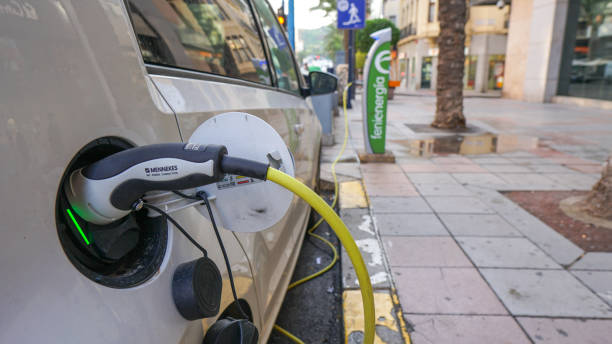 Electric car recharging at a charging point Alicante, España ; September 25, 2021 : Car connected to an urban charging point on a sidewalk in a central street genetic modification photos stock pictures, royalty-free photos & images