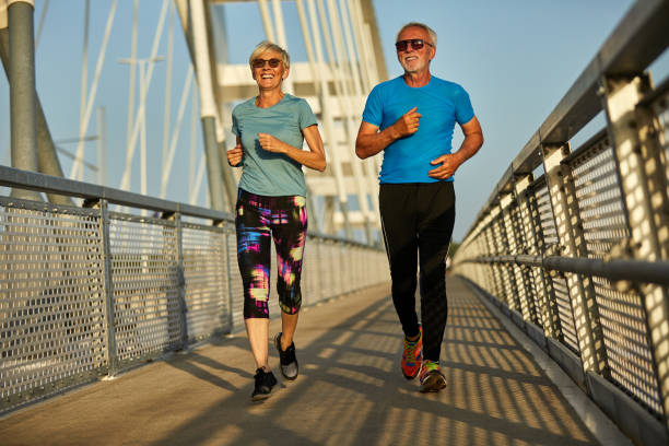 istock Senior couple jogging together over the bridge 1342404452