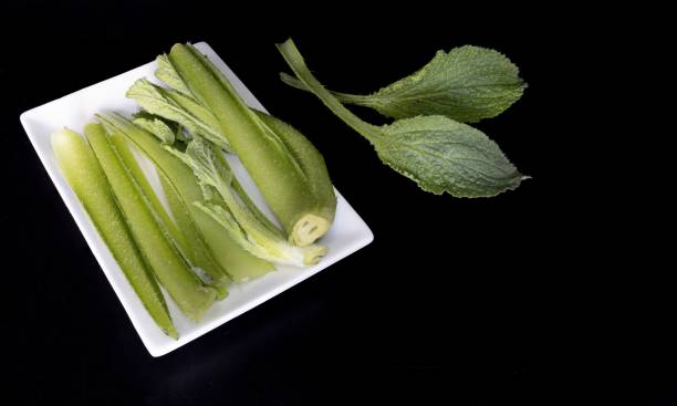 un plato blanco con borraja recién capturada cortada en un fondo negro - borage fotografías e imágenes de stock