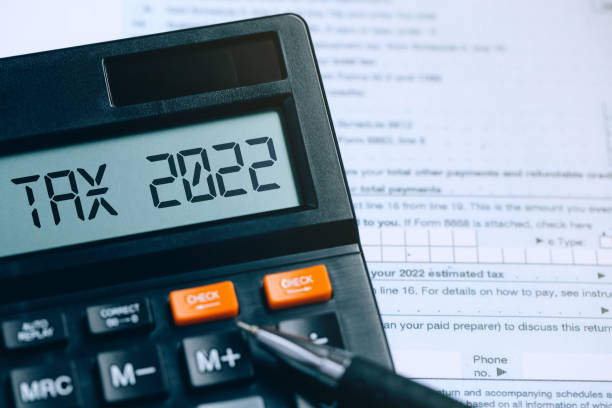 word tax 2022 en la calculadora de documentos. cuenta de resultados. pagando la tasa impositiva. fiscalidad, carga tributaria. concepto empresarial y fiscal. - impuesto fotografías e imágenes de stock