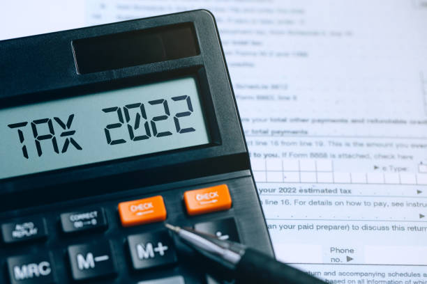 word tax 2022 on the calculator on documents.income statement. paying the tax rate. taxation, taxes burden.business and tax concept. - 稅表 個照片及圖片檔