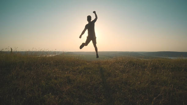 The happy man jumping on a mountain top