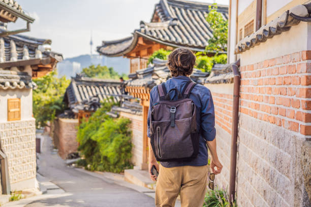 młody człowiek turysta w bukchon hanok village jest jednym ze słynnych miejsc koreańskich tradycyjnych domów, które zostały zachowane. podróż do korei concept - 1354 zdjęcia i obrazy z banku zdjęć