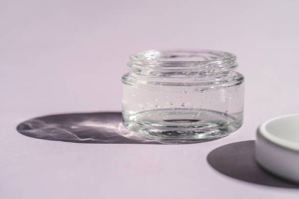 Transparent gel in a jar on a lilac background.