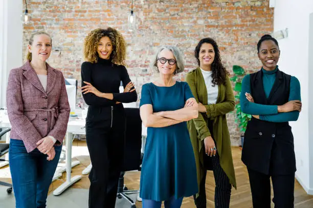 Portrait of successful female business team in office. Multiracial business group standing together and looking at camera.
