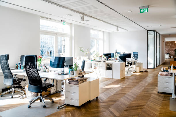 Modern bright office space Still life shot of a modern coworking office space. Spacious workplace with desks and computer. sparse stock pictures, royalty-free photos & images