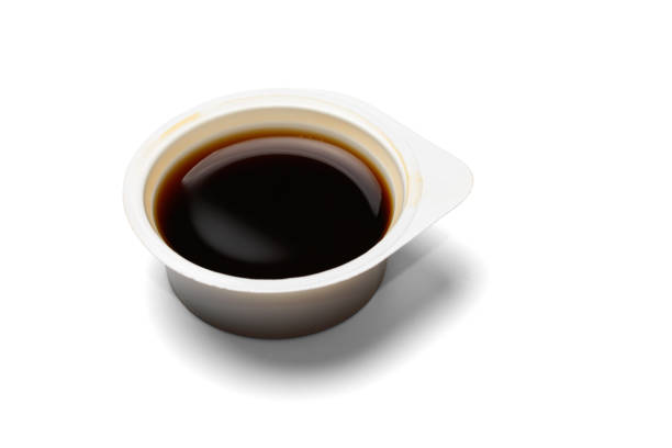 istock Plastic open disposable container with soy sauce. Isolated on a white background with a shadow, close-up 1342423891