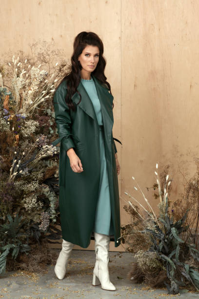 Studio autumn fashion portrait of beautiful confident woman with long brown hair wearing stylish trendy clothes in earth tones. Autumn hairstyles and make up trend concept. retrato de moda de otoño de estudio de hermosa mujer segura de sí misma con cabello largo castaño con ropa elegante y moderna en tonos tierra y posando sobre fondo de madera decorado con flores secas. concepto de peinados otoñales y maquillaje de tende