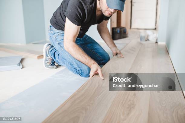 Work Of A Master Floating Flooring Installation Installing Laminate On The Floor Stock Photo - Download Image Now