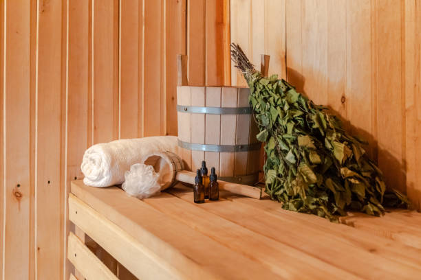 tradicional velho balneário russo spa concept. detalhes interiores sala de vapor de sauna finlandesa com acessórios tradicionais de sauna definir bacia de óleo de toalha de vassoura de bétula. relaxe conceito de banho de aldeia rural - massaging relaxation indoors traditional culture - fotografias e filmes do acervo