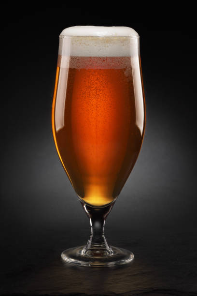 istock Cup with fresh beer with cap of foam on a black. 1342435856