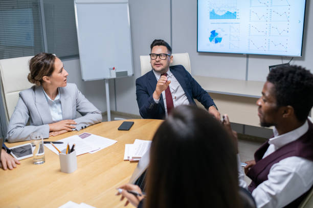istock Mature business coach talking to young managers 1342438512