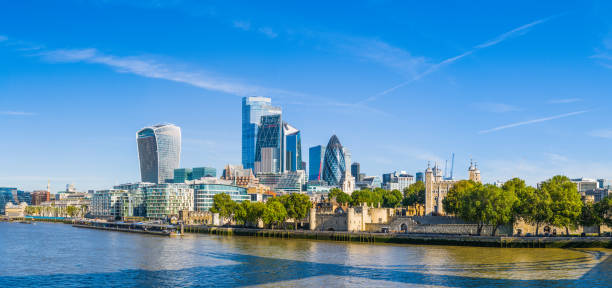 Towers of London financial district skyscrapers overlooking River Thames panorama The futuristic spires of City of London Square Mile financial district skyscrapers overlooking the River Thames Embankment and Tower of London, UK. bankside photos stock pictures, royalty-free photos & images
