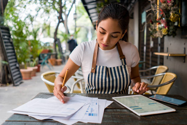 istock Business owner working at a cafe doing the books 1342439489