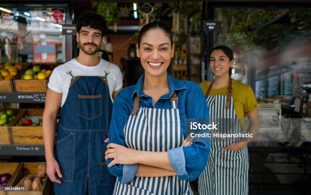 Woman leading a group of salespersons working at a food market Latin American woman leading a group of salespersons working at a local food market - small business concepts Selling Stock Photo