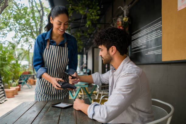 istock Man making a contacless payment at a restaurant using his cell phone 1342439574