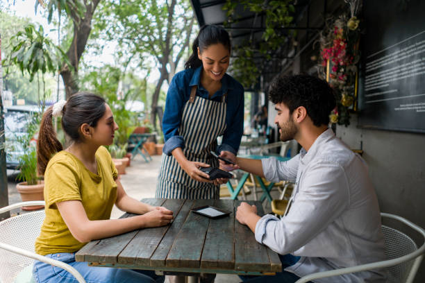 istock Man making a contactless payment with his cell phone at a cafe 1342439581