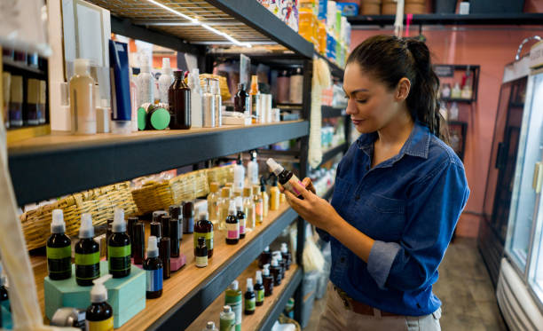 유기농 시장에서 쇼핑하고 보충제를 보는 여성 - 화장품 뉴스 사진 이미지