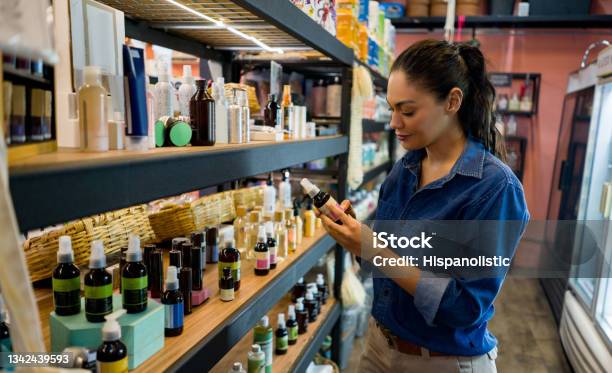 Woman Shopping At An Organic Market And Looking At Supplements Stock Photo - Download Image Now
