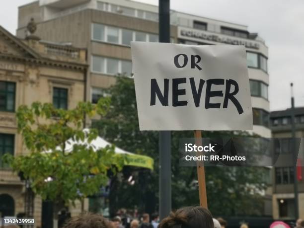 Citizens Displaying Their Politicial Demand To Act Now Or Never During Green Demo Stock Photo - Download Image Now