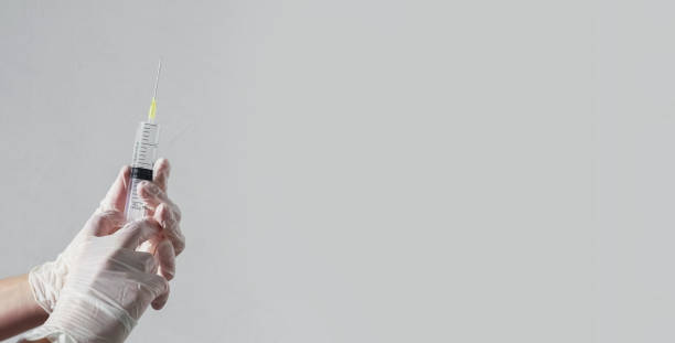 istock Syringe with needle in doctors hands on white banner with copy space for text 1342445866