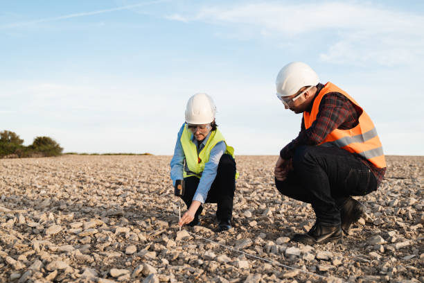 ingenieros de topografía que trabajan en terrenos de construcción - concepto de trabajo topográfico - enfoque en el rostro de la mujer - geología fotografías e imágenes de stock