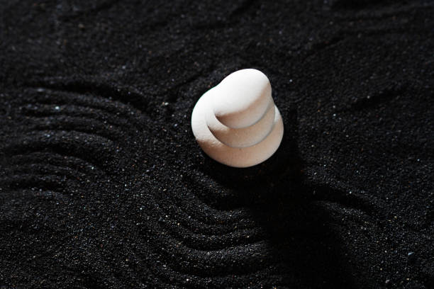istock rock garden, white pebbles on black sand, wavy patterns. 1342446731