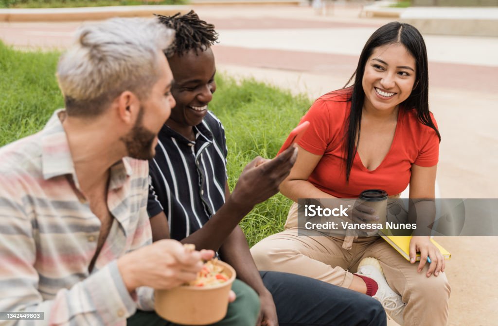 Happy friends having fun eating take away food outdoor in the city - Focus on asian girl face Diverse people having fun eating take away food outdoor in the city - Focus on asian girl face Indigenous Peoples of the Americas Stock Photo