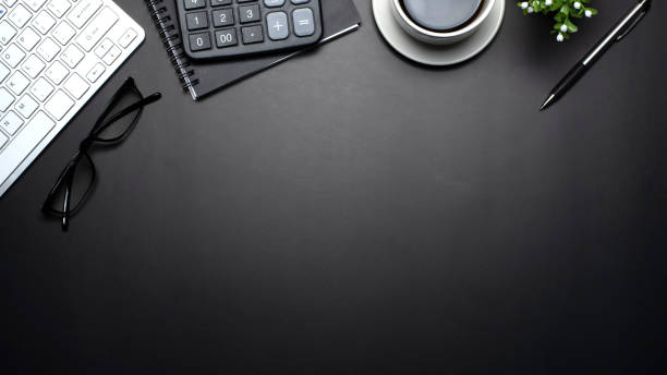 Top view of the keyboard coffee is placed on a black background.