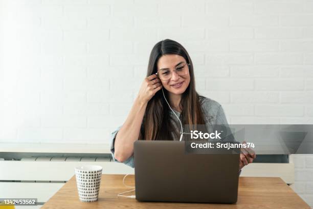 Young Successful Woman Doctor Of Psychology Sitting In A Home Office And And Preparing For Presentation Online Over The Internet On A Laptop Computer Explaining New Methods Of Treating Sick Patients Stock Photo - Download Image Now