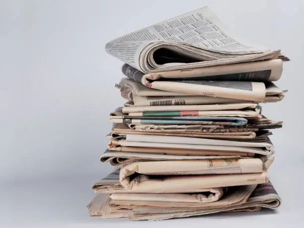 Photo of Pile of newspapers on white background. Journalist, isolated. Information. Stack