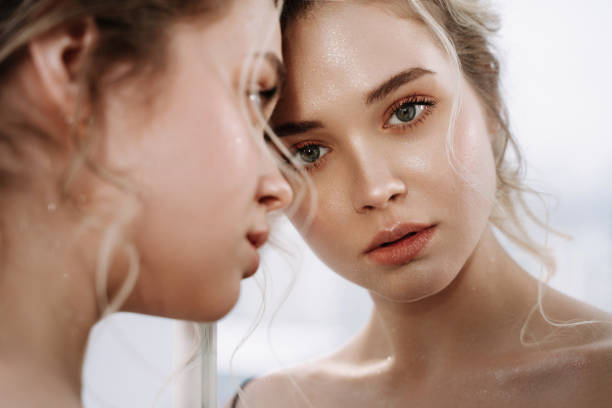 istock Woman Look at Reflection in Mirror Closeup Photo 1342457529