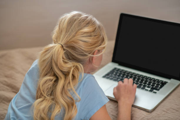 istock A girl lying on the bed and doing her lessons 1342457771