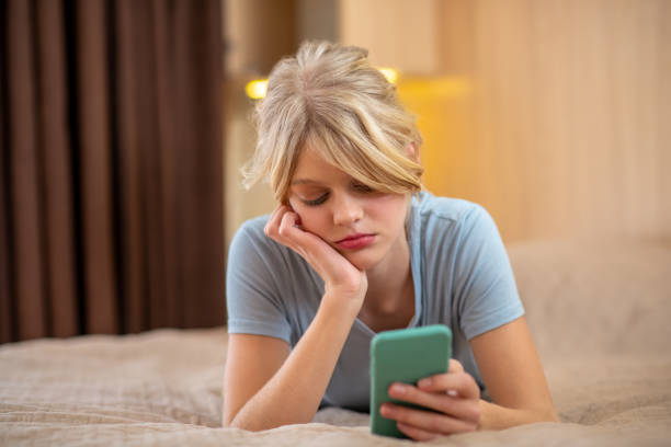 istock A blonde girl lying on bed and spending time online 1342457778