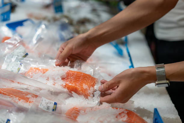 A man picks salmon in the supermarket
