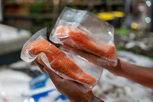 A man picks salmon in the supermarket