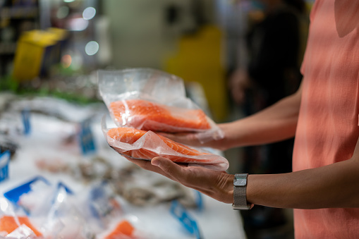 A man picks salmon in the supermarket