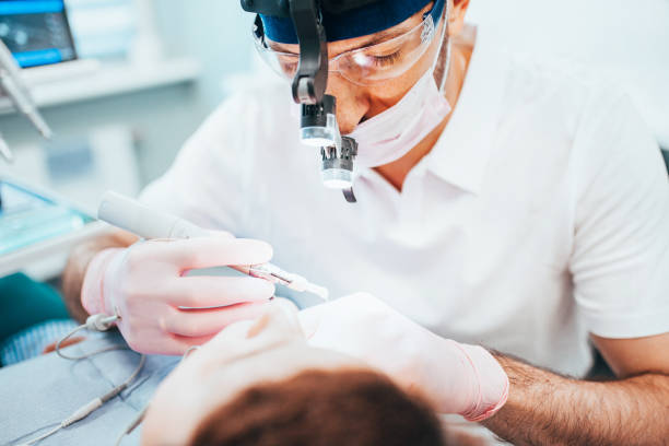 dentist cleans tooth canals of patient and removes nerve - caucasian cavity clinic color image imagens e fotografias de stock
