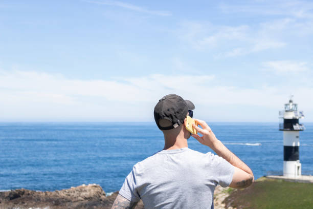 istock Young man talking on his cell phone from the beach, during his summer vacation 1342460548