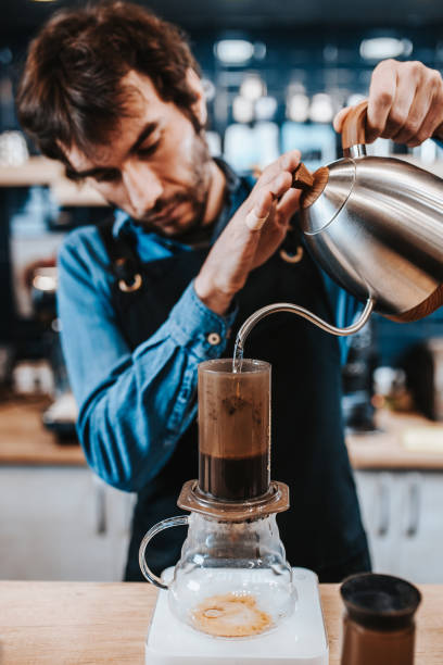 istock Barista pours boiling water from a kettle into a filter 1342465059