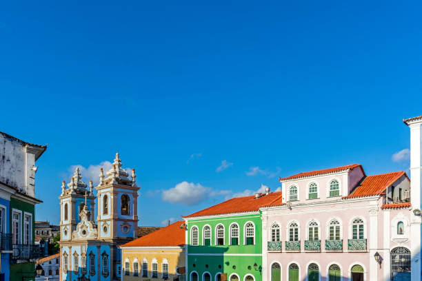 facades of colorful houses and tower of an old baroque church in pelourinho - pelourinho imagens e fotografias de stock