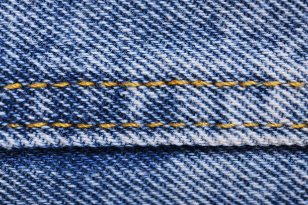 Old blue jeans background and texture close up.Denim seam.