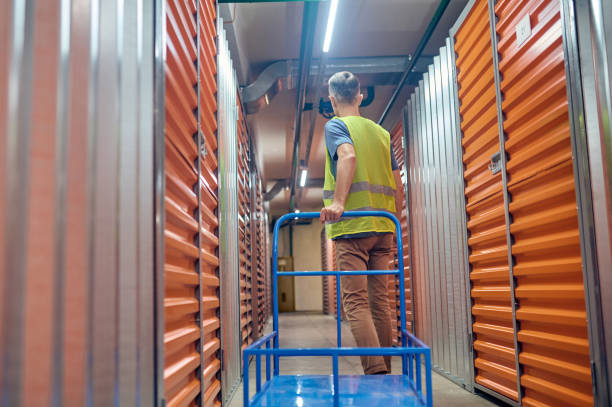 istock Man with cart walking through warehouse 1342469672