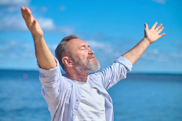 istock Man with closed eyes stretching arms to sides 1342474066